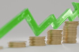 five stacks of coins increasing in size with arrow showing an upward direction