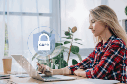 a lady sitting at a desk infront of a laptop with the letters GDPR displayed on the screen