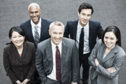 a group of five people dressed in dark business suits